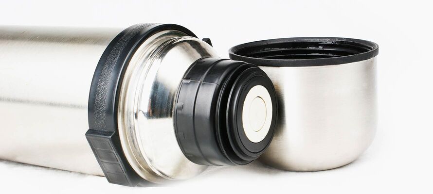 liegende Thermoskanne mit stehendem Deckel-Becher